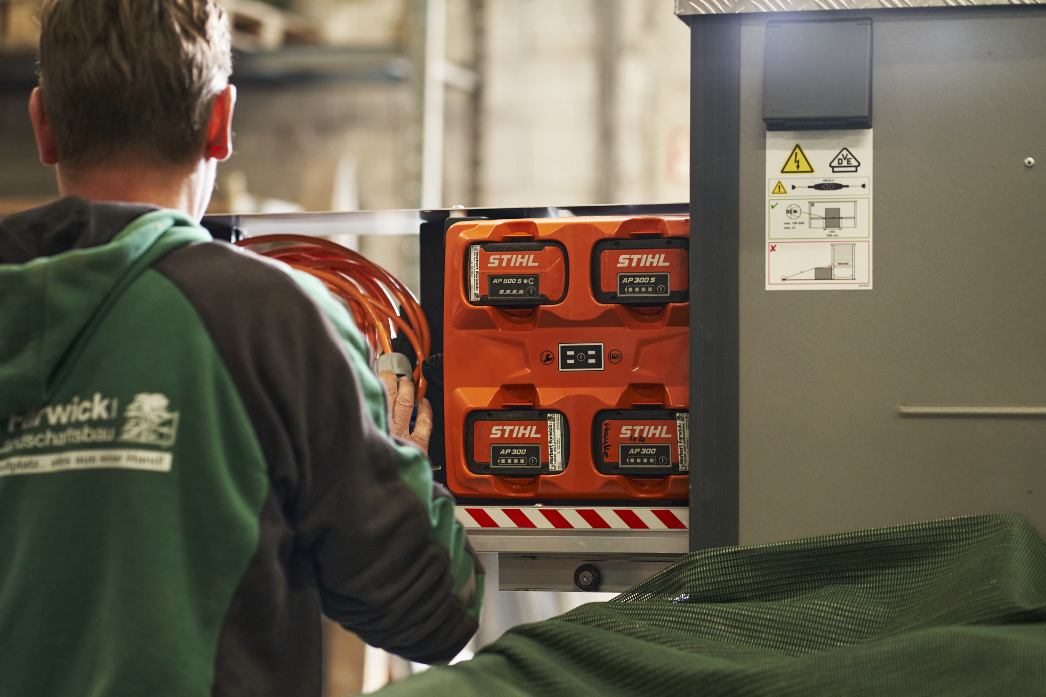 Un empleado de Farwick GmbH visto de espaldas delante de un bottTainer powered by STIHL